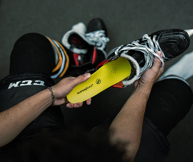 A POV shot of a hockey player inserting Superfeet's Hockey Performance Insoles into his skates. 