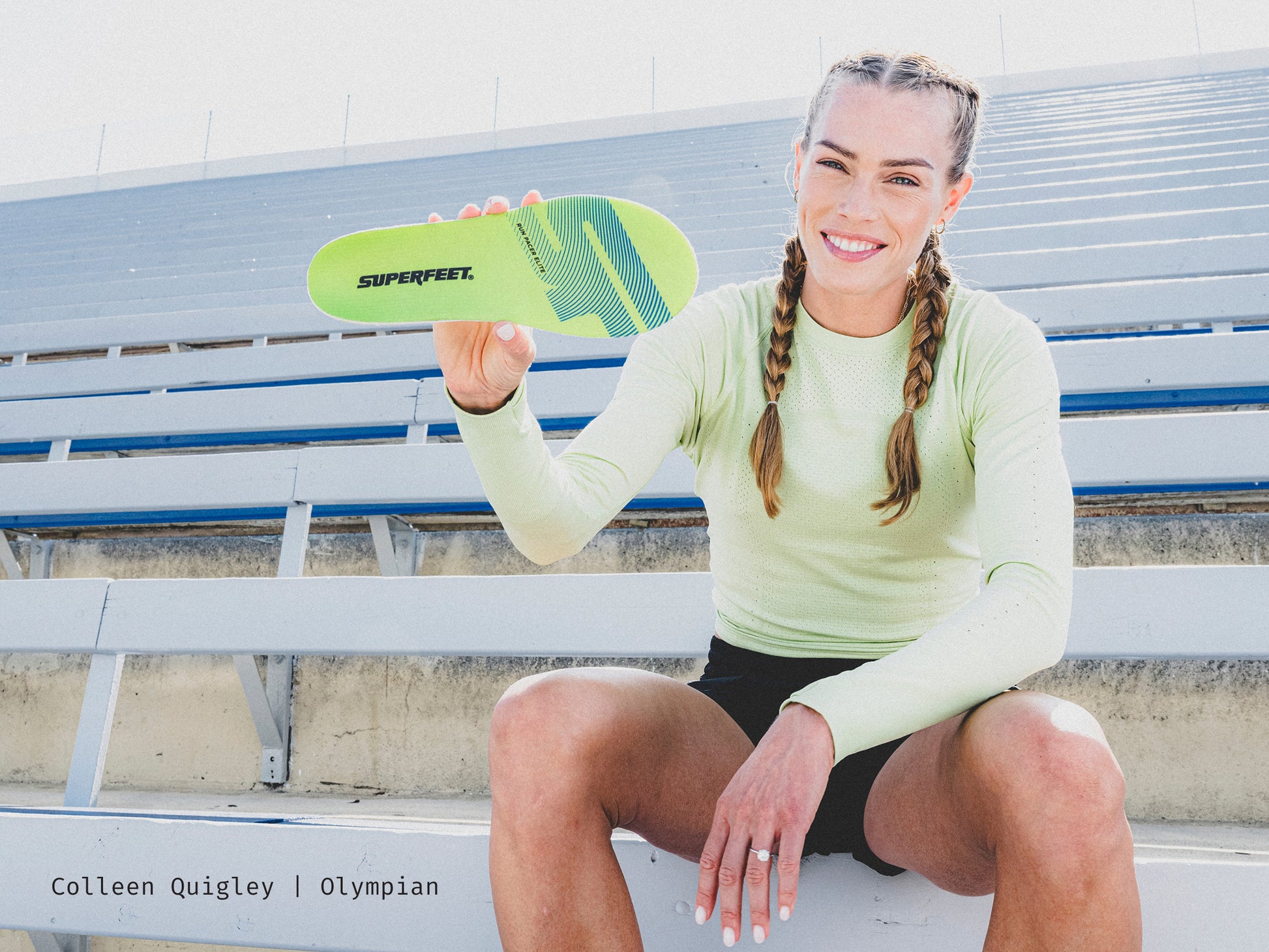 U.S.A's Olympian Colleen Quigley holding Superfeet's Run Pacer Elite insole while sitting outside on a stadium bench. 
