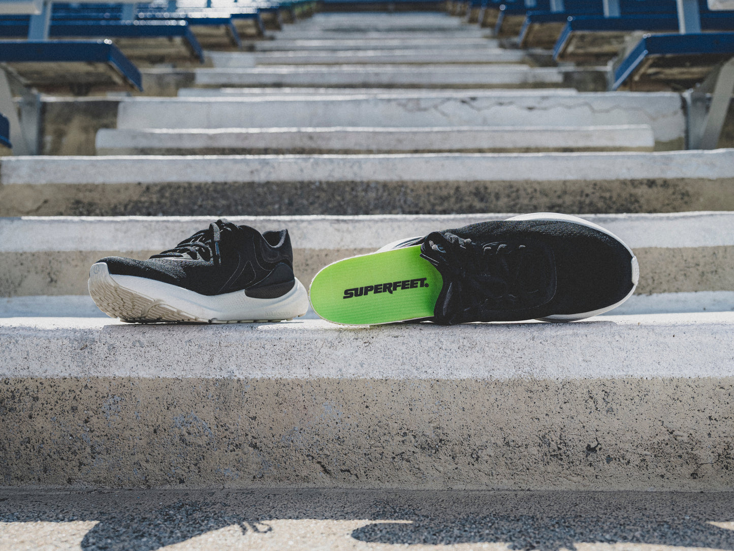 Superfeet's Run Pacer Elite insole sticking out of a black athletic shoe outside.