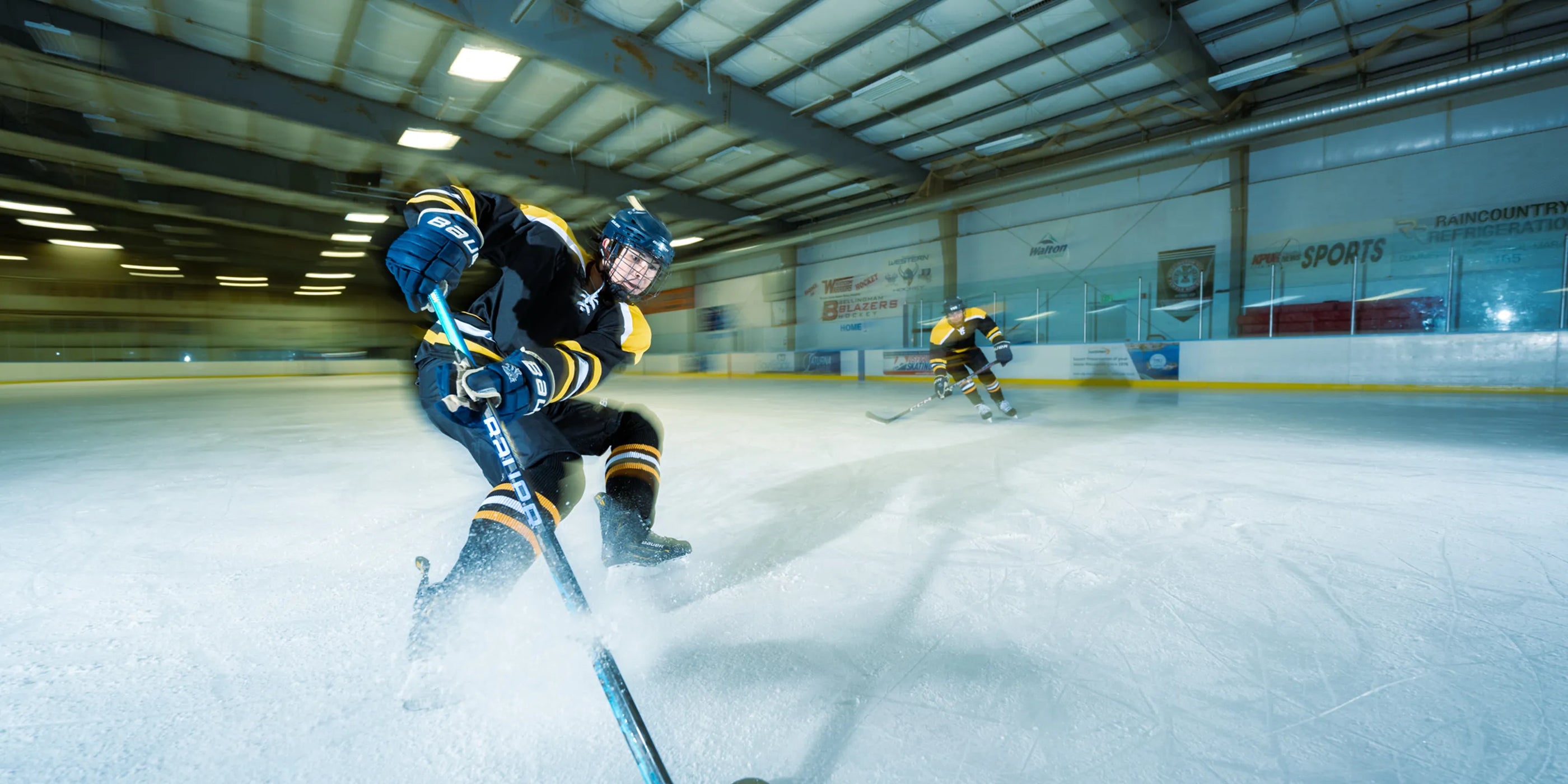 Two Hockey Players on ice playing hockey.